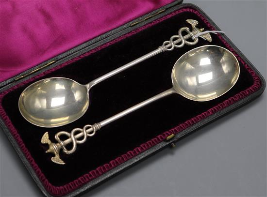 A cased pair of Victorian silver serving spoons with caduceus finials Aldwinckle & Slater, London, 1893, 20.3cm.